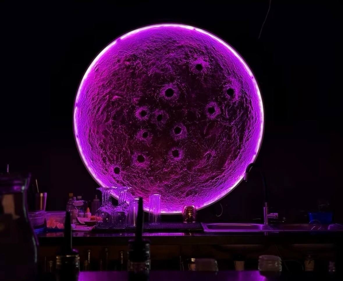 Segundo piso de Lunático: barra oscura con una luna iluminada en violeta