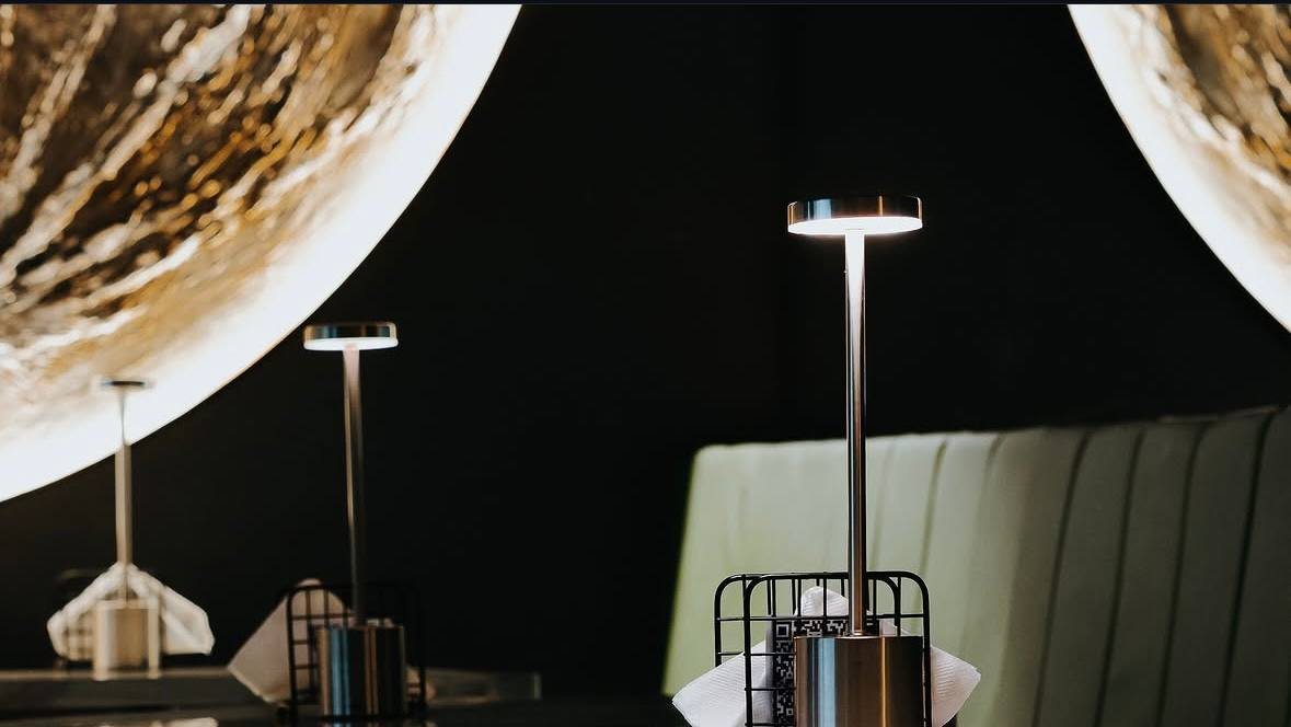 Mesas con lámparas frente a una luna dorada iluminada