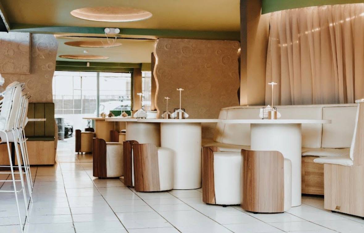 Primer piso de Lunático: salón luminoso en tonos crema, madera y verde